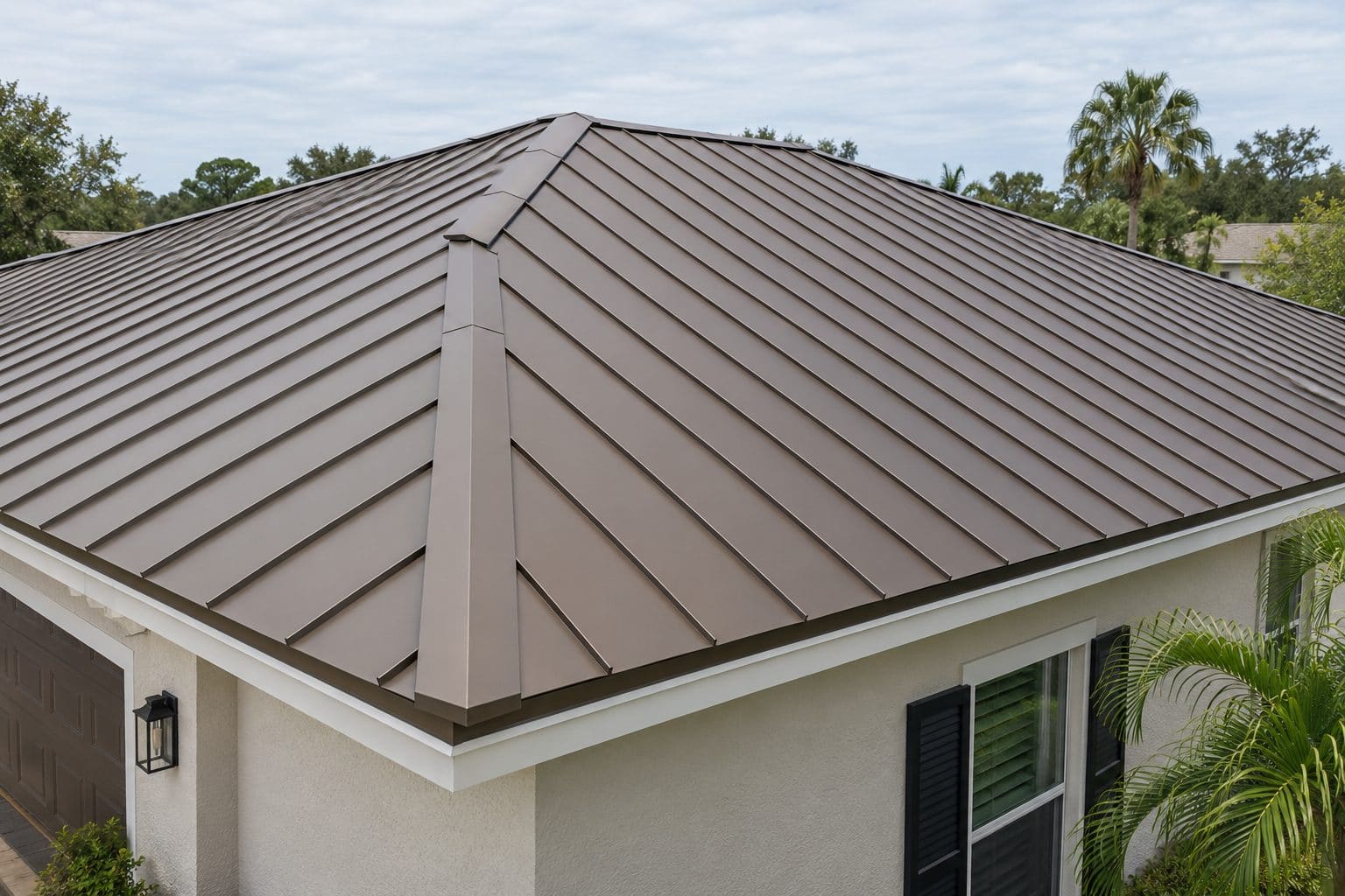 Standing seam metal roof in bronze with clean hip ridges and concealed fasteners on a Florida home